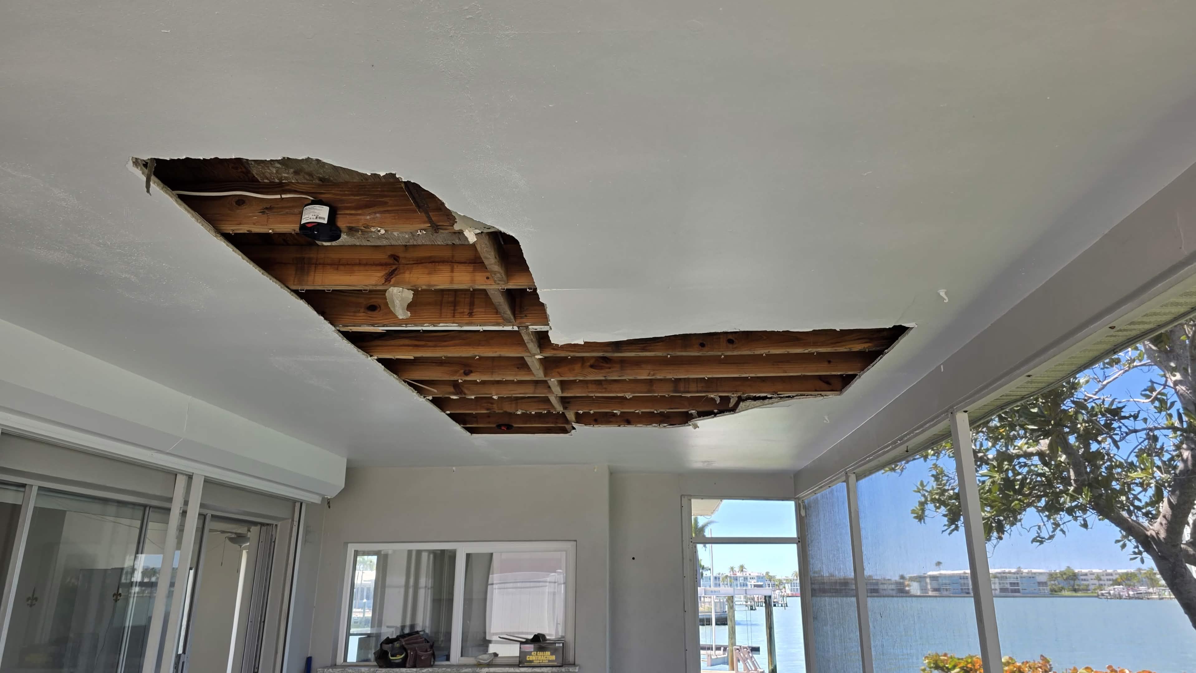 Damaged patio ceiling with a hole before repair